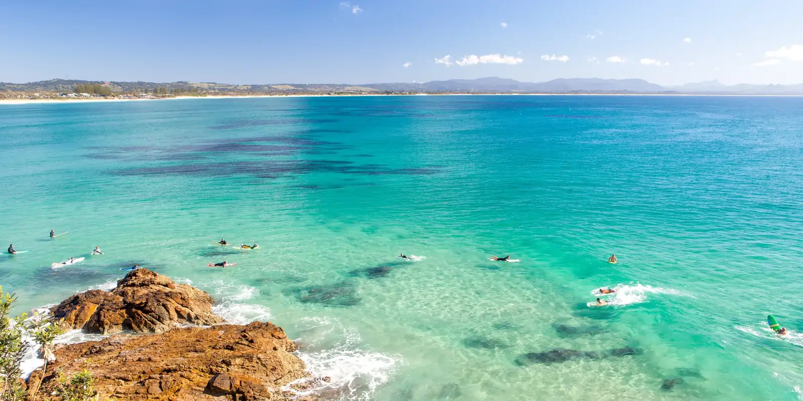 Agua turquesa y surfistas en Wategos, junto al cabo de Byron Bay