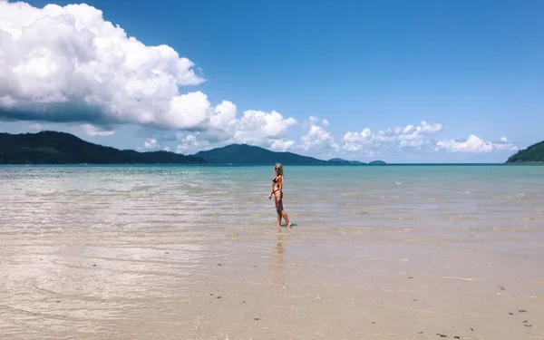 Estudiante en una playa de aguas transparentes en las Whitsunday, Queensland