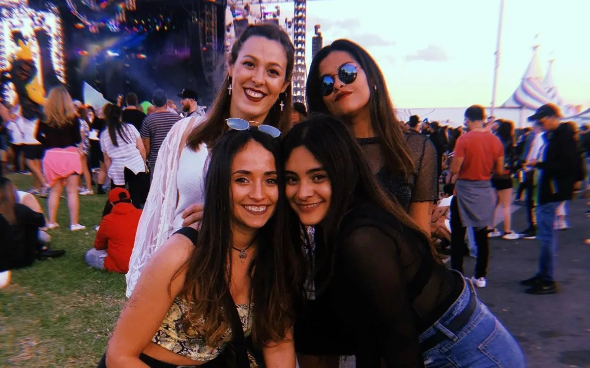Tres estudiantes sonriendo en un festival de música en Melbourne