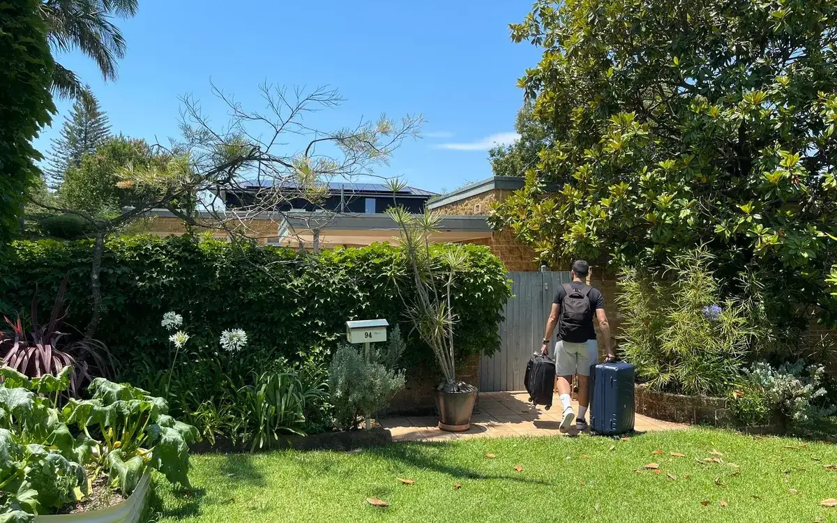 Estudiante llegando con dos maletas a su casa en Australia