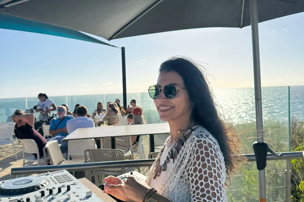 Lusiana, estudiante de Salta, pinchando música en una terraza frente al mar en Perth