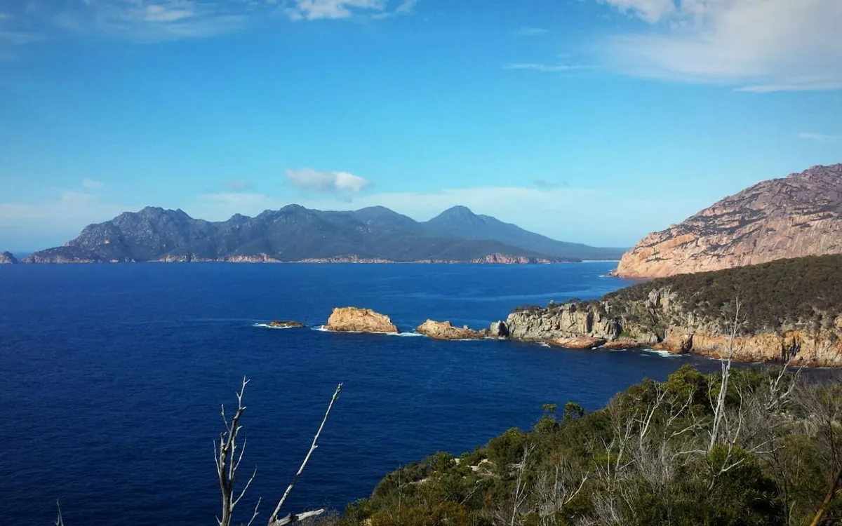 Costa de Tasmania con el mar azul intenso y las montañas al fondo