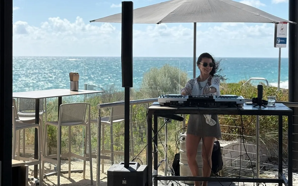Terraza de un bar frente al mar en Perth, con una estudiante pinchando música