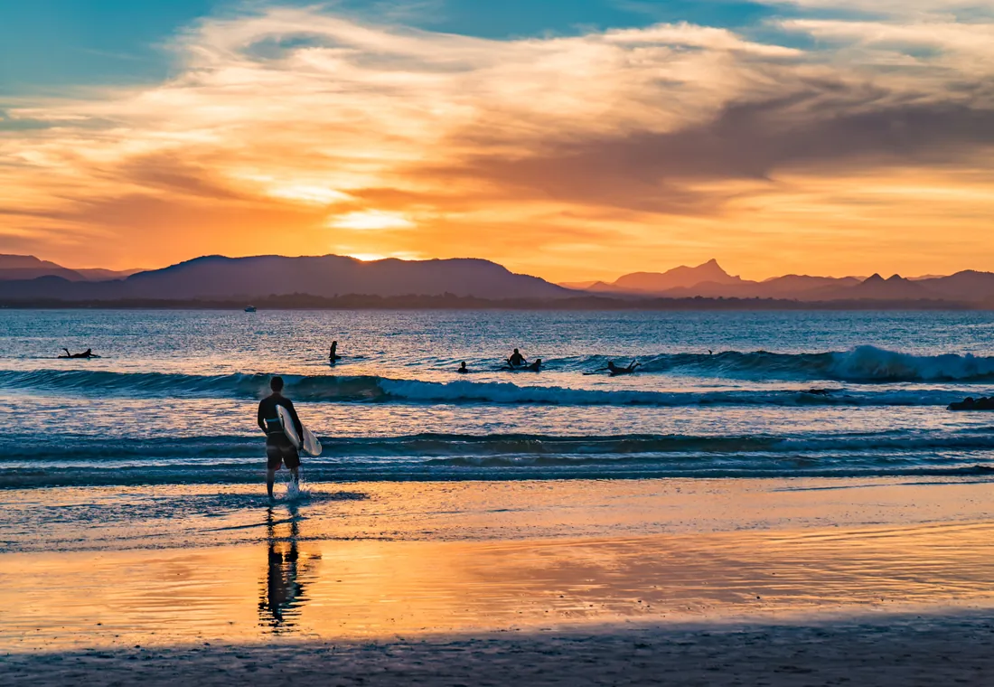 Un surfista en la playa al atardecer