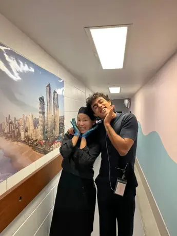 Dos estudiantes con el uniforme de trabajo en el pasillo de un hotel