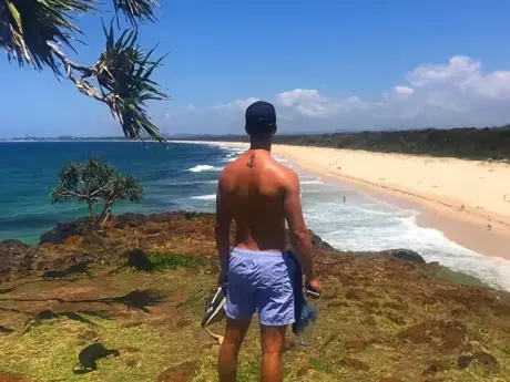Estudiante en un cabo sobre una playa de arena blanca