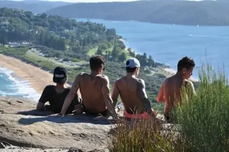 Cuatro amigos sentados en un mirador sobre Palm Beach, en Sydney