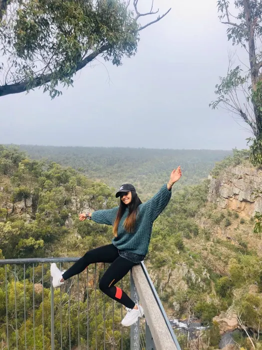 Estudiante en un mirador sobre el bosque australiano