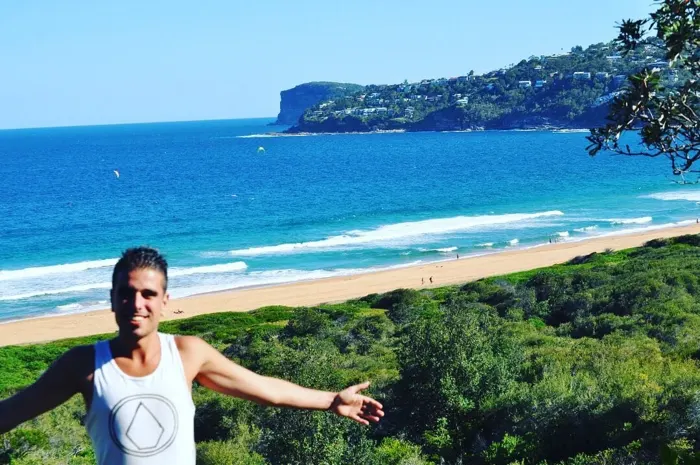 Estudiante de Salta con los brazos abiertos en un mirador sobre la playa