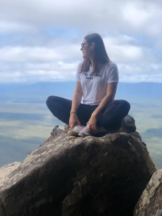 Estudiante de Salta sentada en una roca sobre un valle australiano