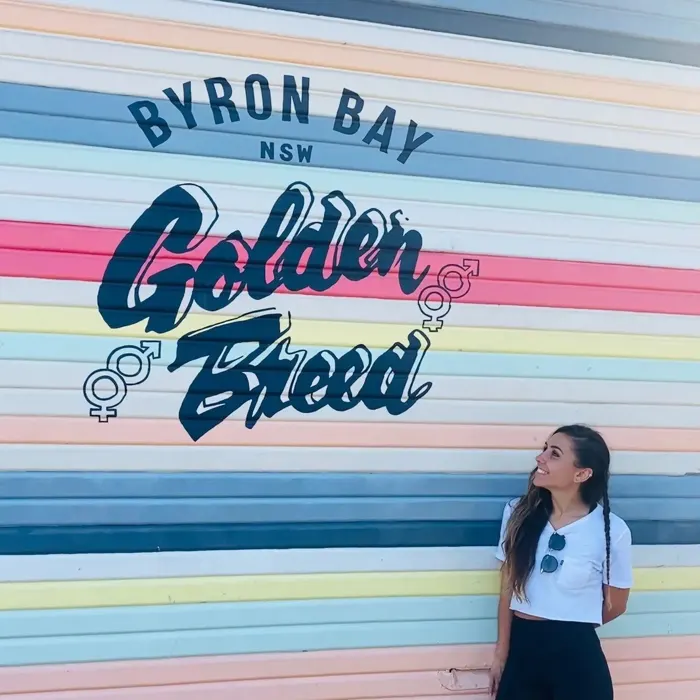 Estudiante junto a un mural de Byron Bay
