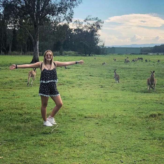 Estudiante entre canguros en un prado australiano