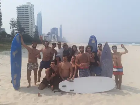 Grupo de estudiantes con tablas de surf en la playa de Surfers Paradise