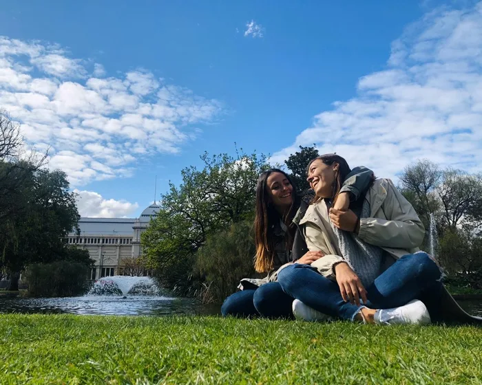 Dos estudiantes riendo en un parque