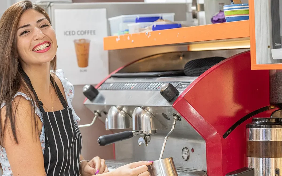 Estudiante de Inforum texturizando leche en la máquina de café de la escuela, en su curso de barista