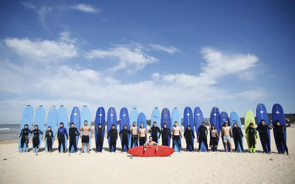 Grupo de estudiantes de ILSC con tablas de surf en la playa