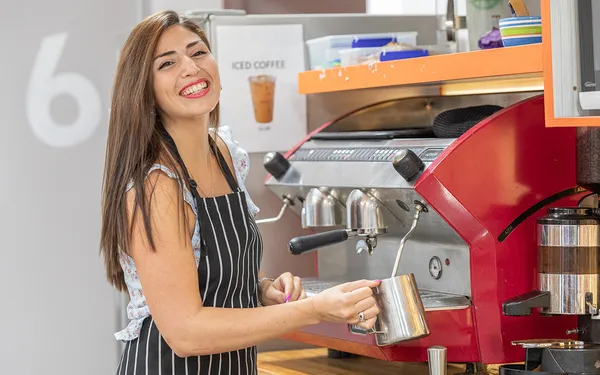Estudiante preparando un café en la máquina de barista de la cafetería de Inforum