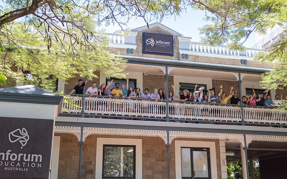 Estudiantes saludando desde el balcón del edificio de Inforum Education en Southport