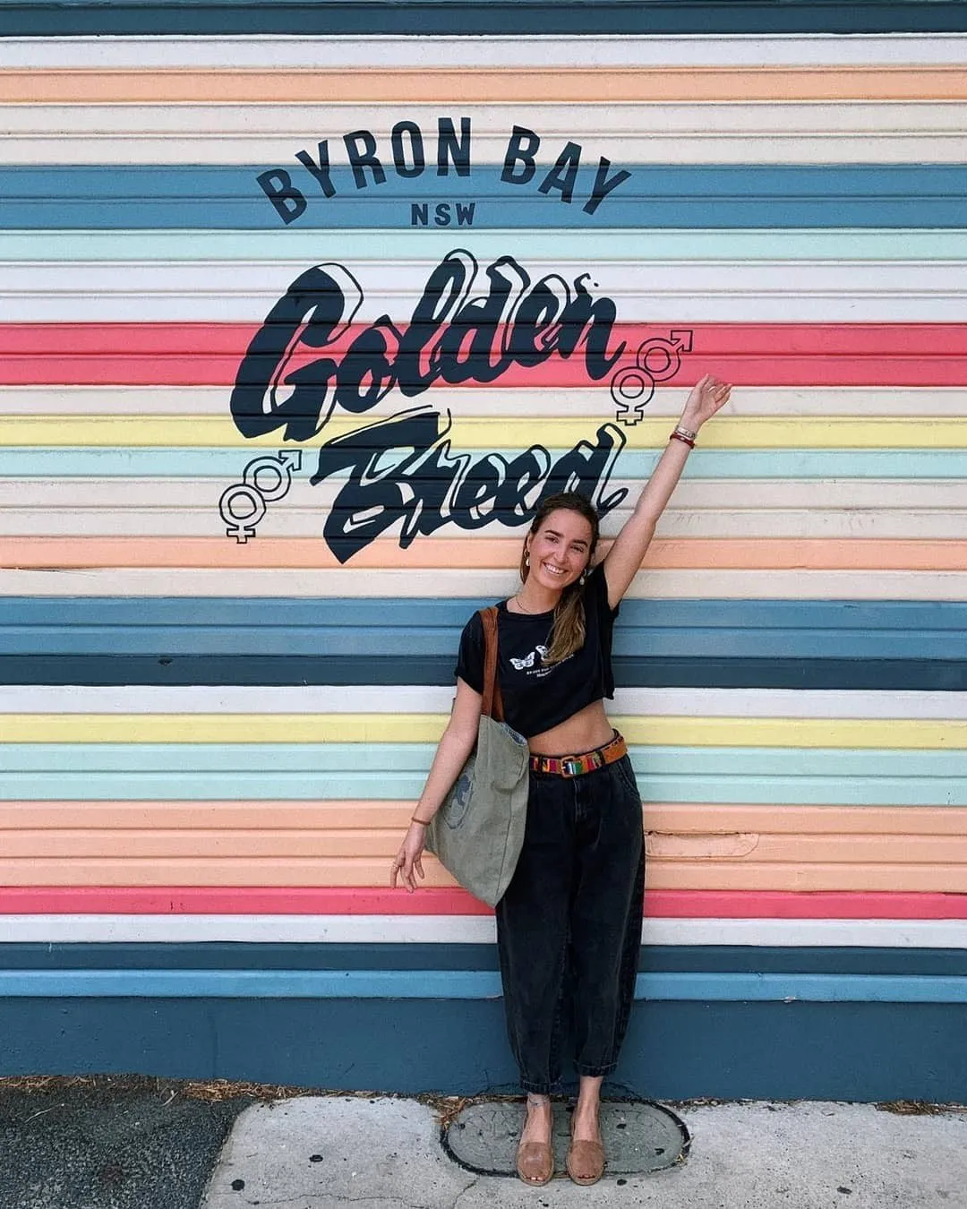 Una estudiante de Salta ante el mural de colores de Golden Breed, en Byron Bay