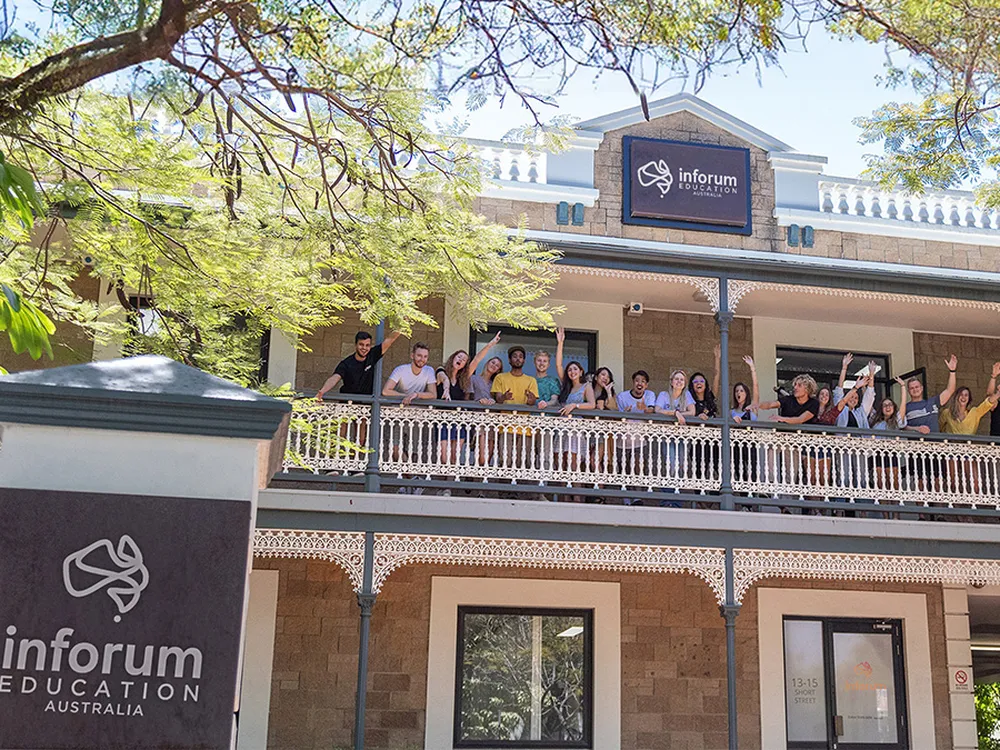 Estudiantes saludando desde el balcón de su escuela de inglés