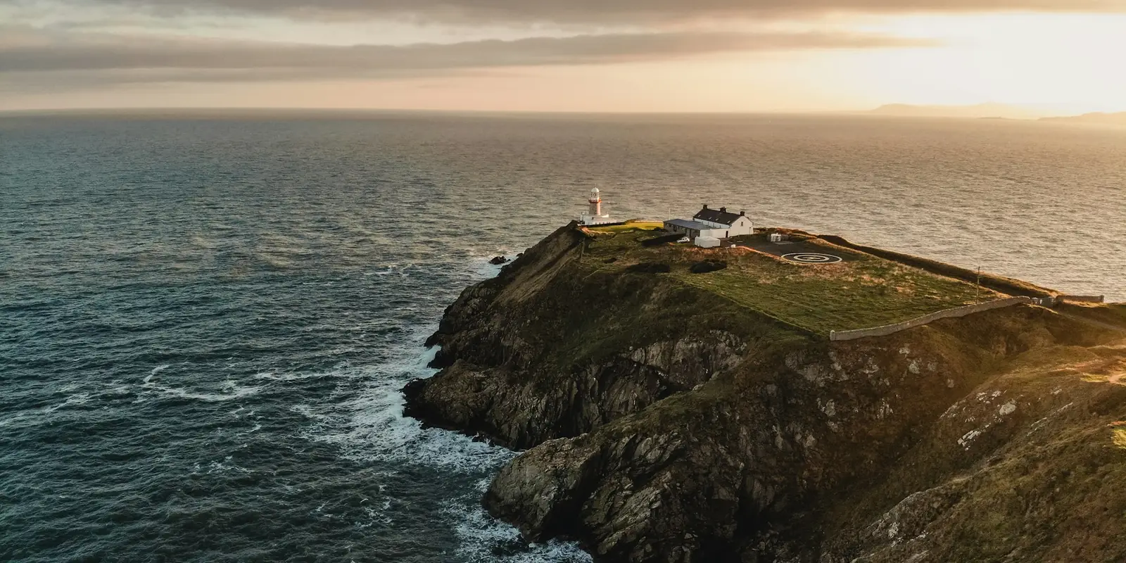 El faro de Baily sobre los acantilados de Howth al atardecer, junto a Dublín
