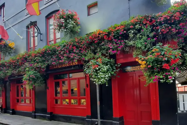 Un pub de Dublín con la fachada roja llena de flores