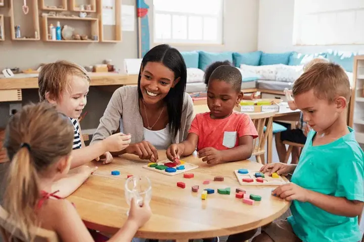 Educadora jugando con niños en una clase de educación infantil
