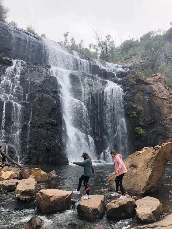 Dos estudiantes en las rocas frente a la cascada MacKenzie, en los Grampians