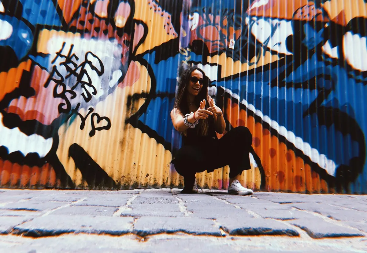 Una estudiante entre los grafitis de colores de un callejón de Melbourne