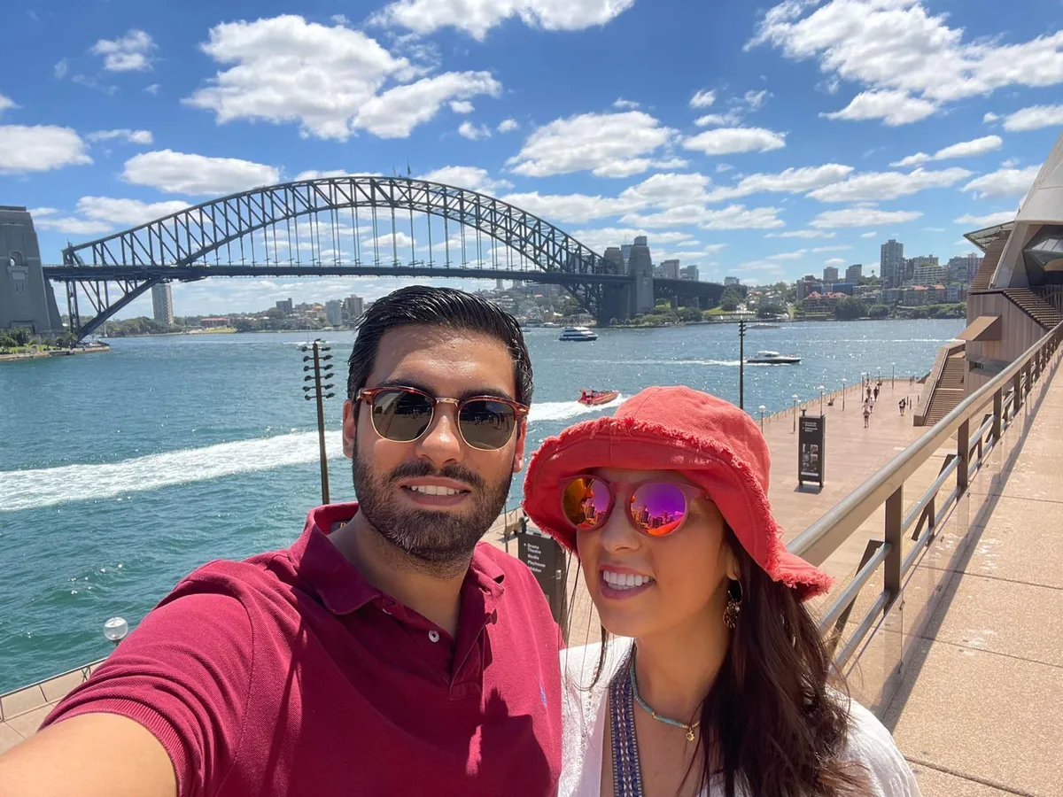 Pareja de estudiantes de Salta en Sydney con el Harbour Bridge detrás