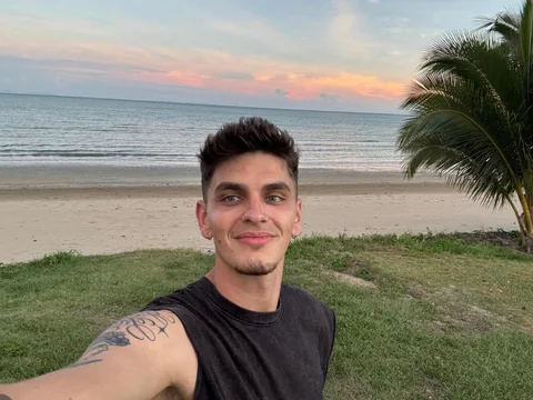 Alex, estudiante de Salta, en una playa de Queensland al atardecer