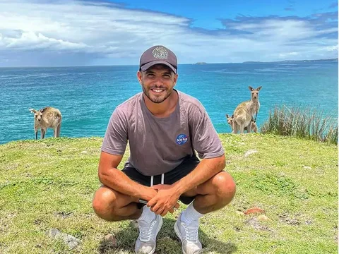 Hicham, estudiante de Salta, con canguros junto al mar en Coffs Coast