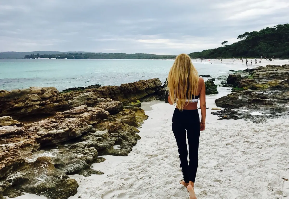 Una estudiante caminando por la arena blanca de Hyams Beach, en Jervis Bay